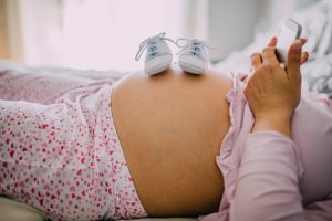 Baby shoes on pregnant belly